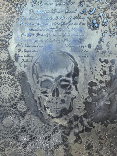Ein durchscheinender Schädel vor einem filigranen, mandalaartigen Hintergrund.