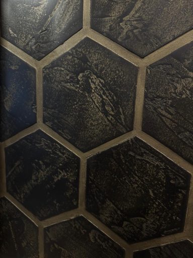 Sechseckige schwarze Fliesen mit texturiertem Muster.