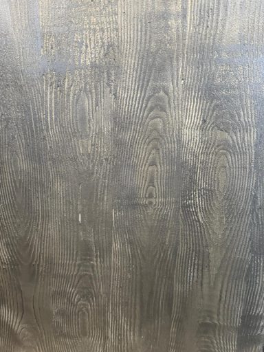 Dunkle Holzoberfläche mit feiner Maserung und strukturierter Textur.